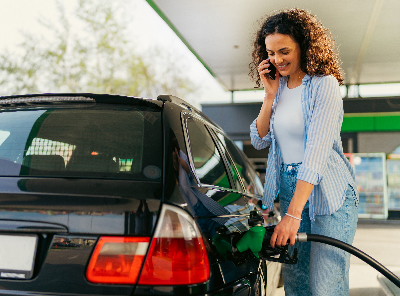 women putting gas into car